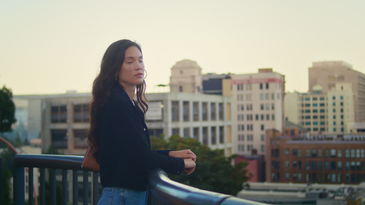 una mujer hermosa de pie cerca de la barandilla de la ciudad. un joven turista asiático mirando la ciudad.