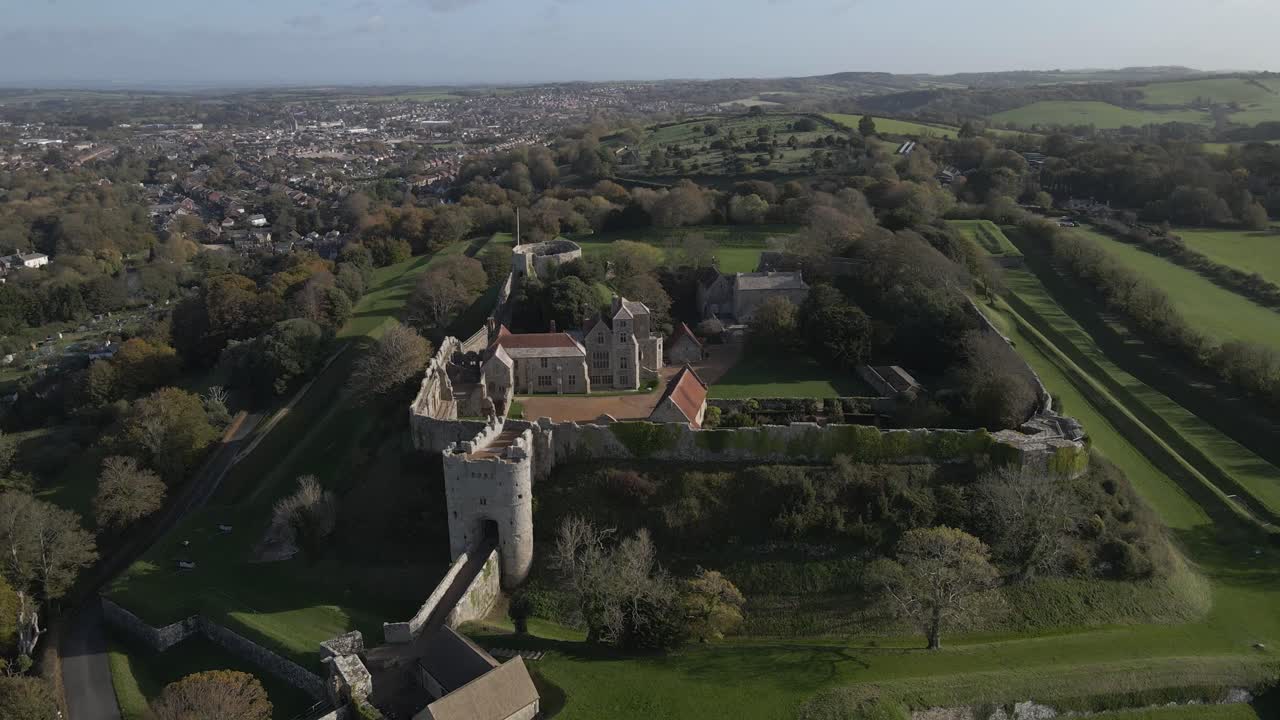 Castle a great fortress which began life as an Anglo-Saxon earthwork defence against Viking raids. Drone moving upwards showing the castle and the green fields in the background