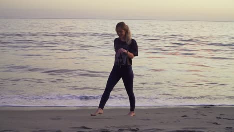 Blonde-female-running-away-from-the-waves-on-the-beach