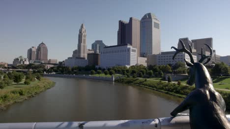 Estatua-De-Ciervo-En-El-Puente-De-La-Calle-Principal-En-Columbus,-Ohio-Con-Horizonte-En-El-Fondo-Panorámico-De-Izquierda-A-Derecha