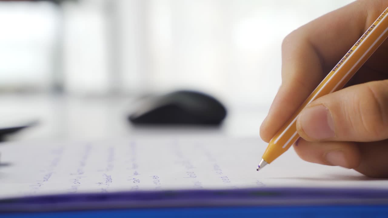 escribiendo con lápiz en papel en primer plano.