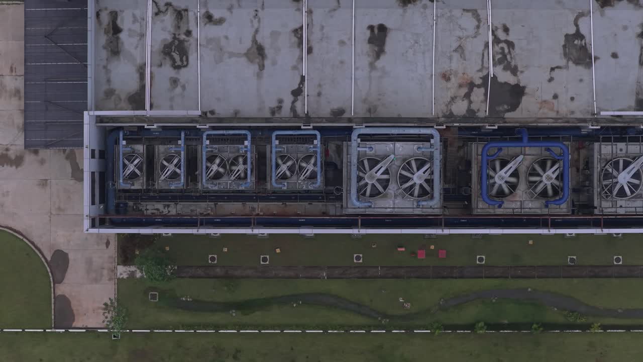 Overhead drone shot slowly moving sideways over a large data center, showing the powerful air conditioning and ventilation units on the roof