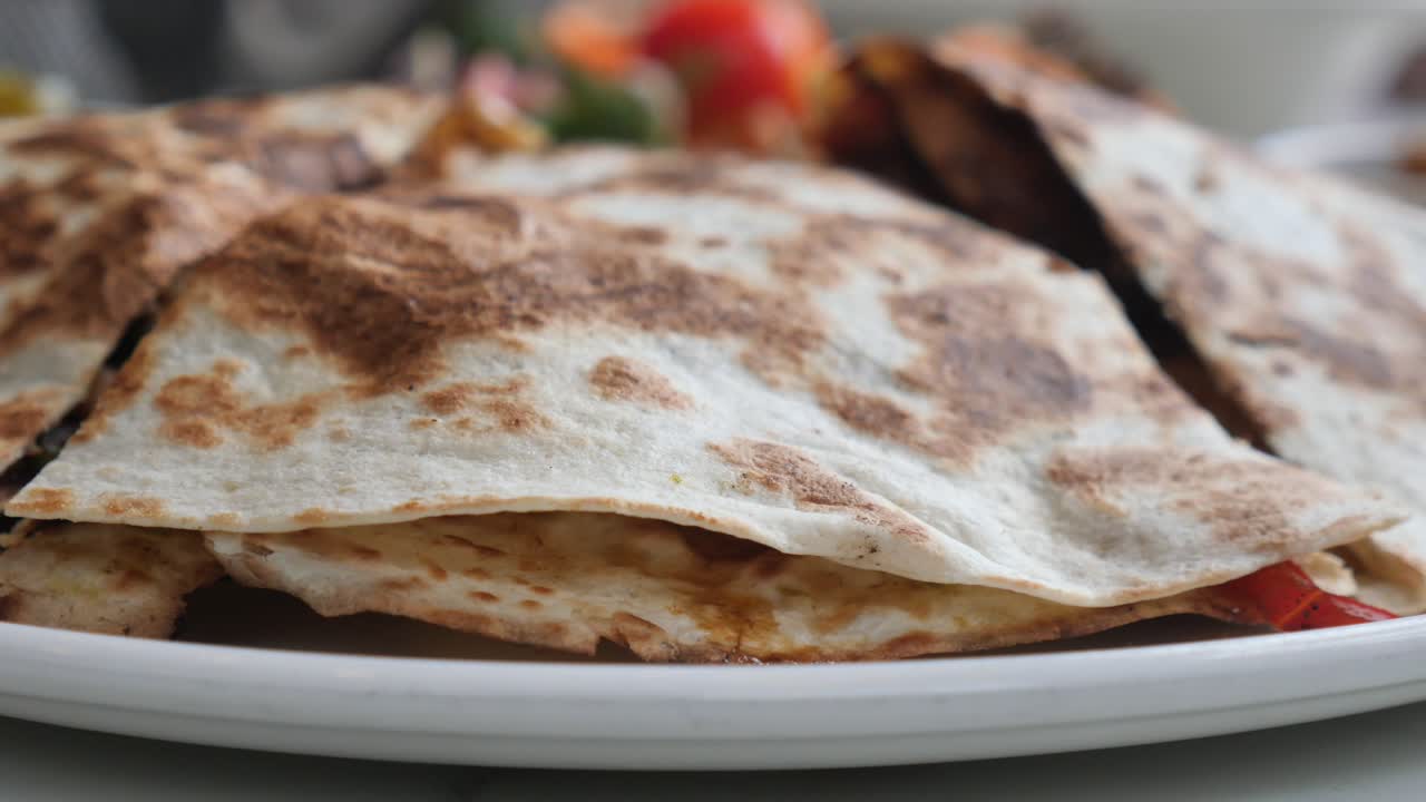 Nærbilde av deilige quesadillas servert på en hvit tallerken