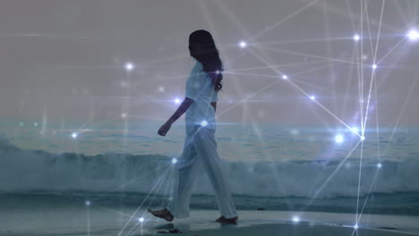 animación de puntos de luz sobre una mujer biracial caminando por la playa