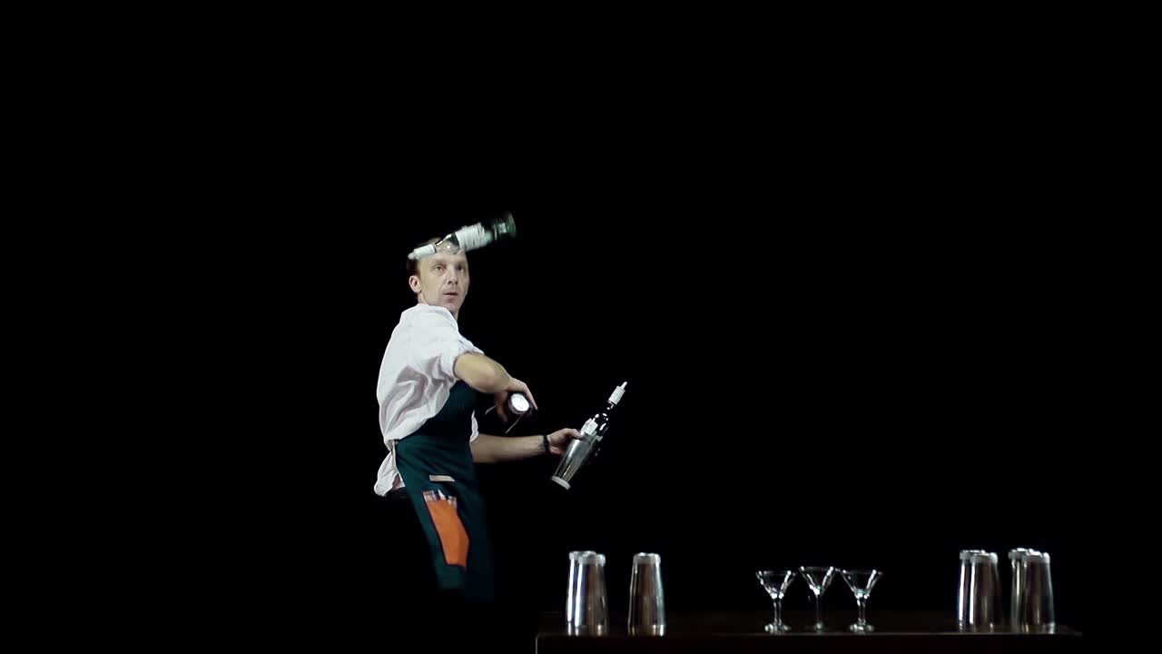 Barman che fa giocoleria con bottiglie e shaker