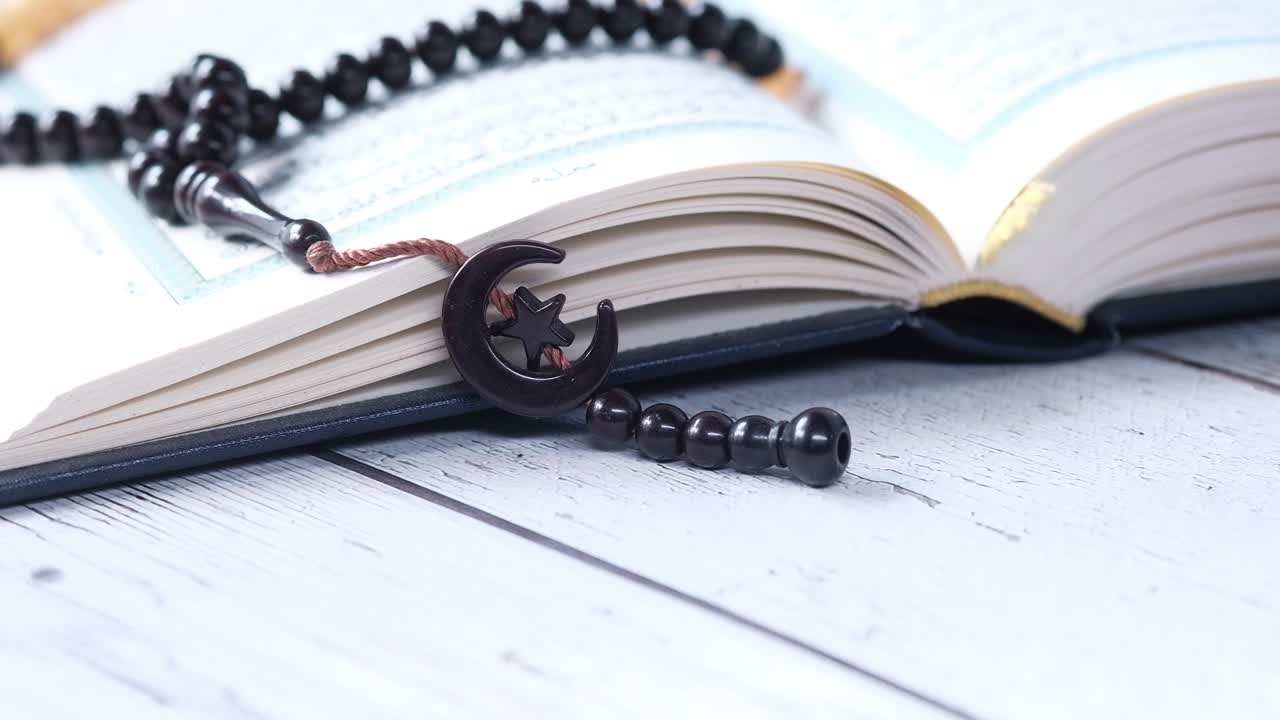 abre el corán con cuentas de oración y luna creciente