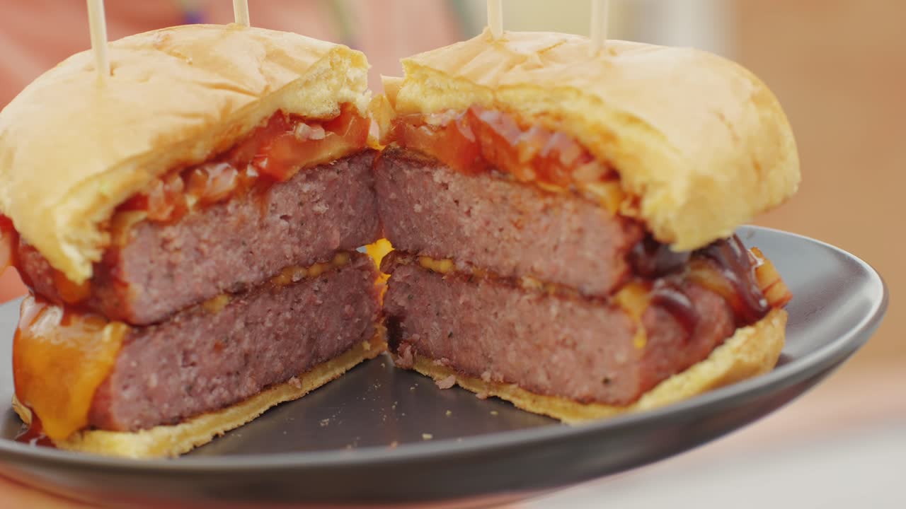 Making American fat smash burger with fresh tomatoes and cheese on grill close-up macro. Beef or pork cutlet smashing by burger press. The chef in kitchen of the restaurant making cutlets for burgers - smash burger beefsteak. Fast and street food concept.