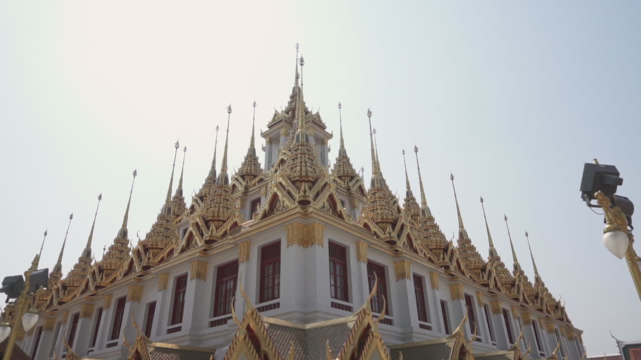 Tilt up  of an important traditional buddhist castle temple still used by monks to meditate in the city of Bangkok in Thailand on a sunny summer day