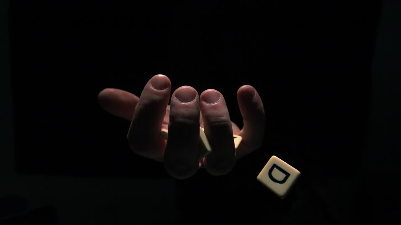 la mano agarrando piezas de letra deletreando mi mano al revés