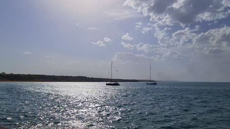 barcos amarrados y reflejos del sol en el agua de mar
