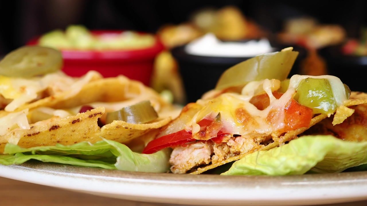 Primo piano di nachos con formaggio fuso, peperoni e jalapenos
