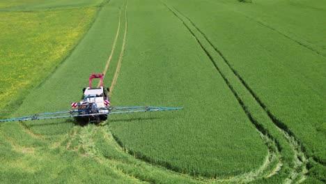 a tractor turning in a field leaving wheel tracks as it goes, aerial