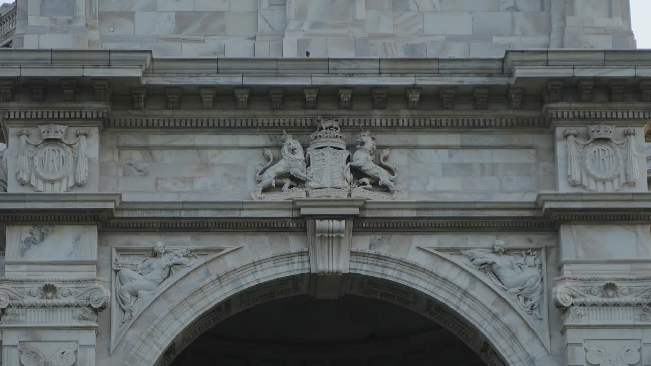 Close-up of a white marble monument with detailed carvings and a coat of arms