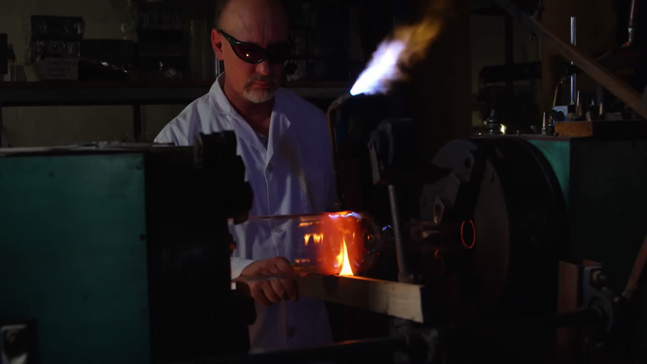 vista frontal de un trabajador masculino maduro creando vidrio en una fábrica de vidrio 4k