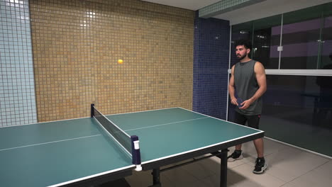 a man serves the ball several times in an indoor ping pong match near the table on time-lapse shot