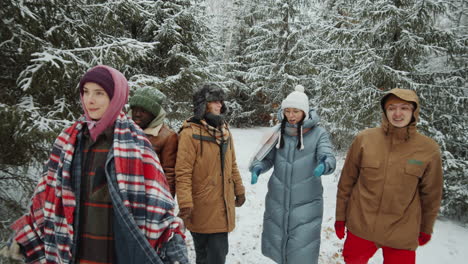amigos caminando en el bosque de invierno