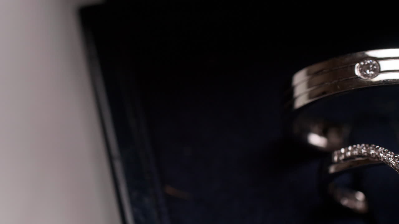 deslizando una caja de un par de anillos de compromiso de la derecha al lado izquierdo del marco