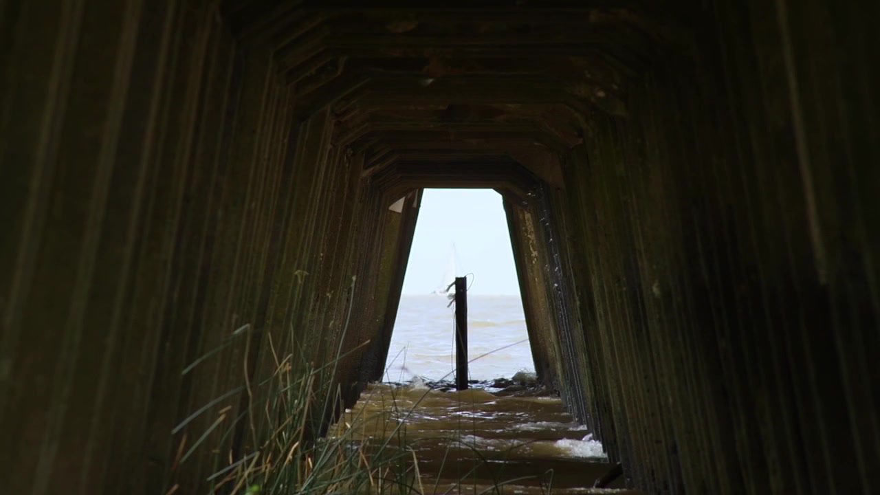 Wind and waves seen beneath a pier.