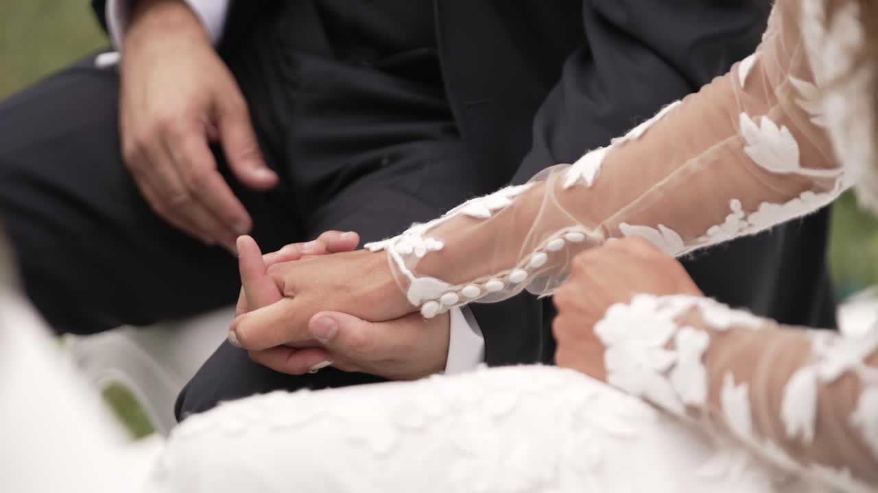 Close-up of Bride and Groom Holding Hands at Wedding Ceremony