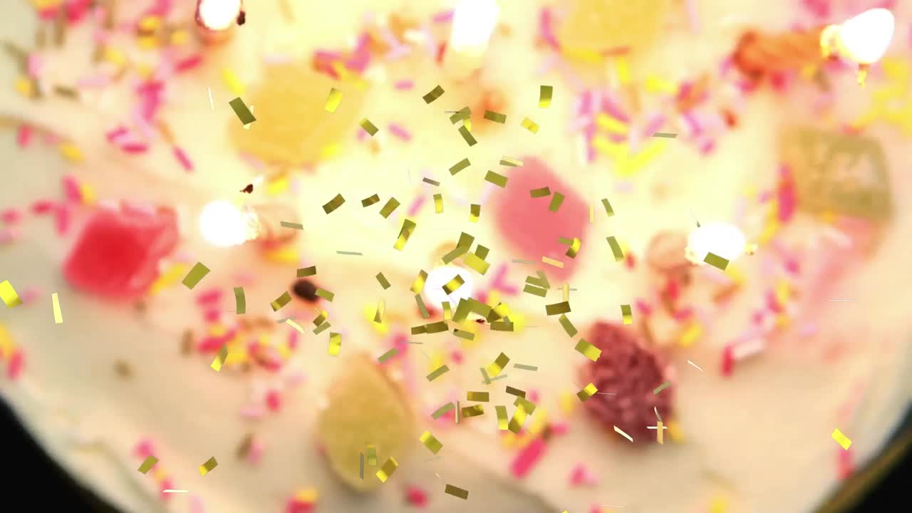 생일 케이크에 켜진  ⁇ 불 위에 떨어지는 금 콘페티의 애니메이션