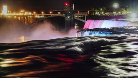 niagara falls at night with the glow of the city lights behind 1