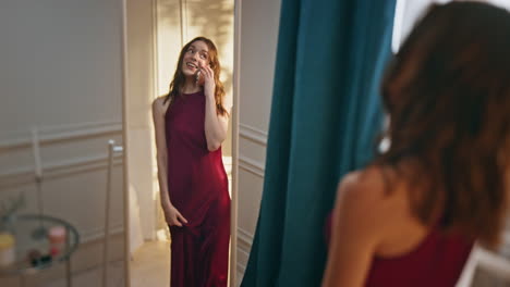 smiling girl talking smartphone in mirror reflection. happy woman getting ready