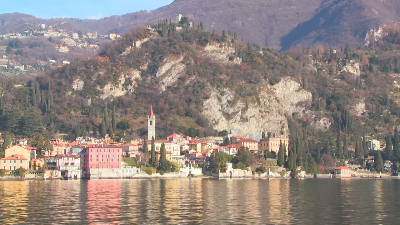 pov desde un barco a orillas del lago de como con la ciudad de varenna y los alpes italianos de fondo