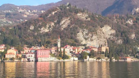 POV-from-a-boat-of-the-shores-of-Lake-Como-with-the-town-of-Varenna-and-the-Italian-Alps-in-background