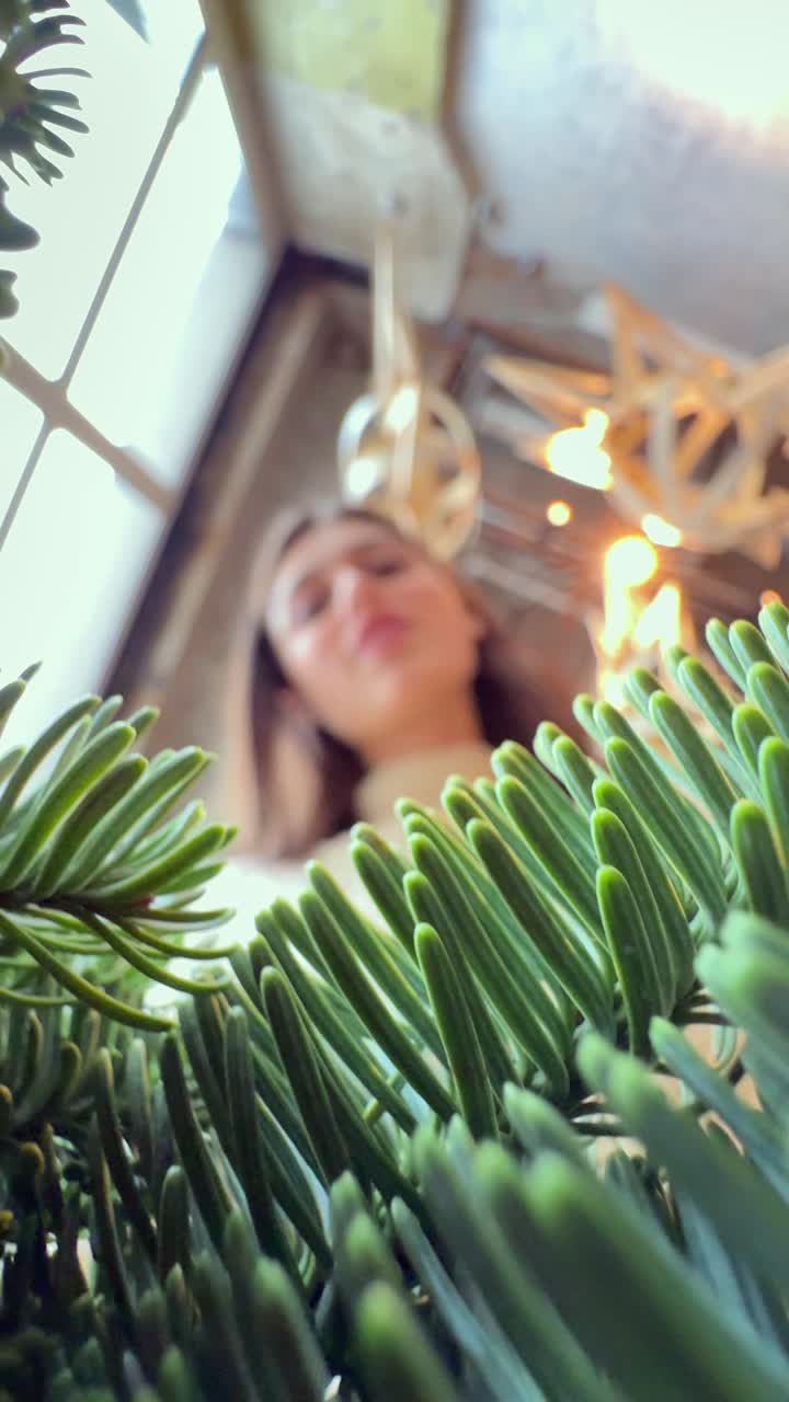 아래에서 크리스마스 트리를 바라보는 여자