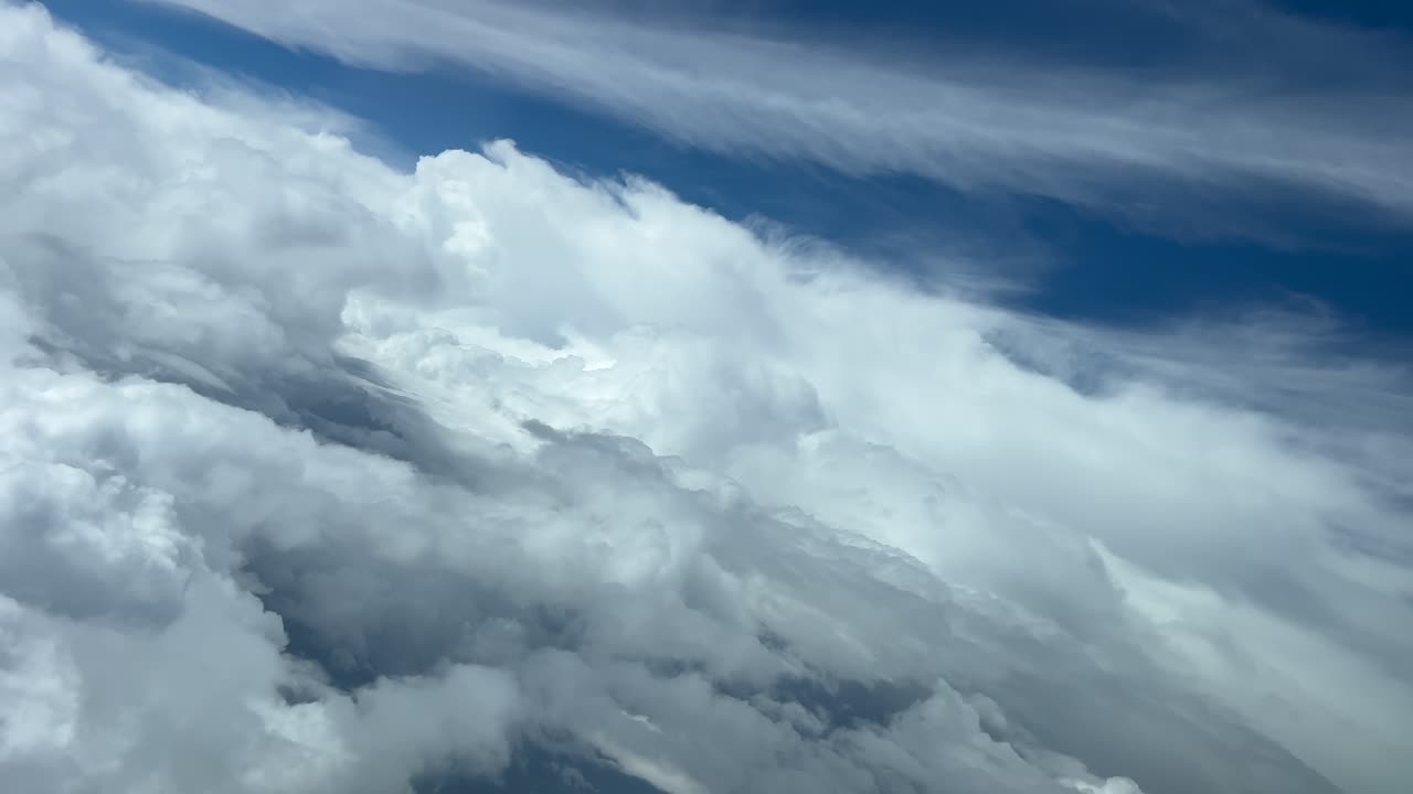 Cloudscape at the eyes of the pilot’s of a jet doing a left turn on a stormy blue sky. Immersive pilo’s perspective. 4K