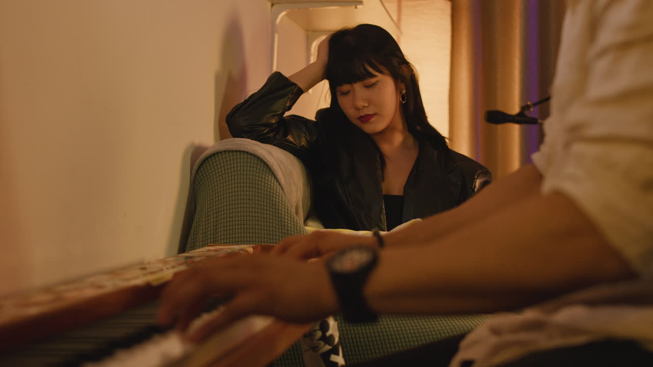 A pianist playing a piano for a woman