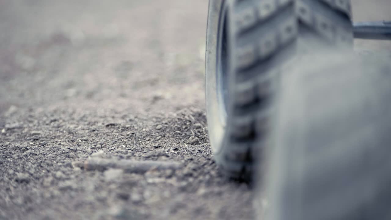 砂利を蹴立てて急発進し、カメラから遠ざかるRCカーのタイトショット