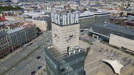 Cinematic-aerial-footage-of-the-Riga-clock-tower-on-a-sunny-day-with-cars-in-the-background