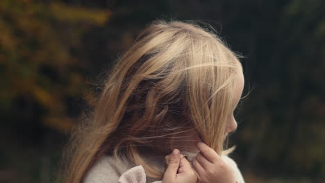 cute little girl untangles long blond hair, portrait, slow motion