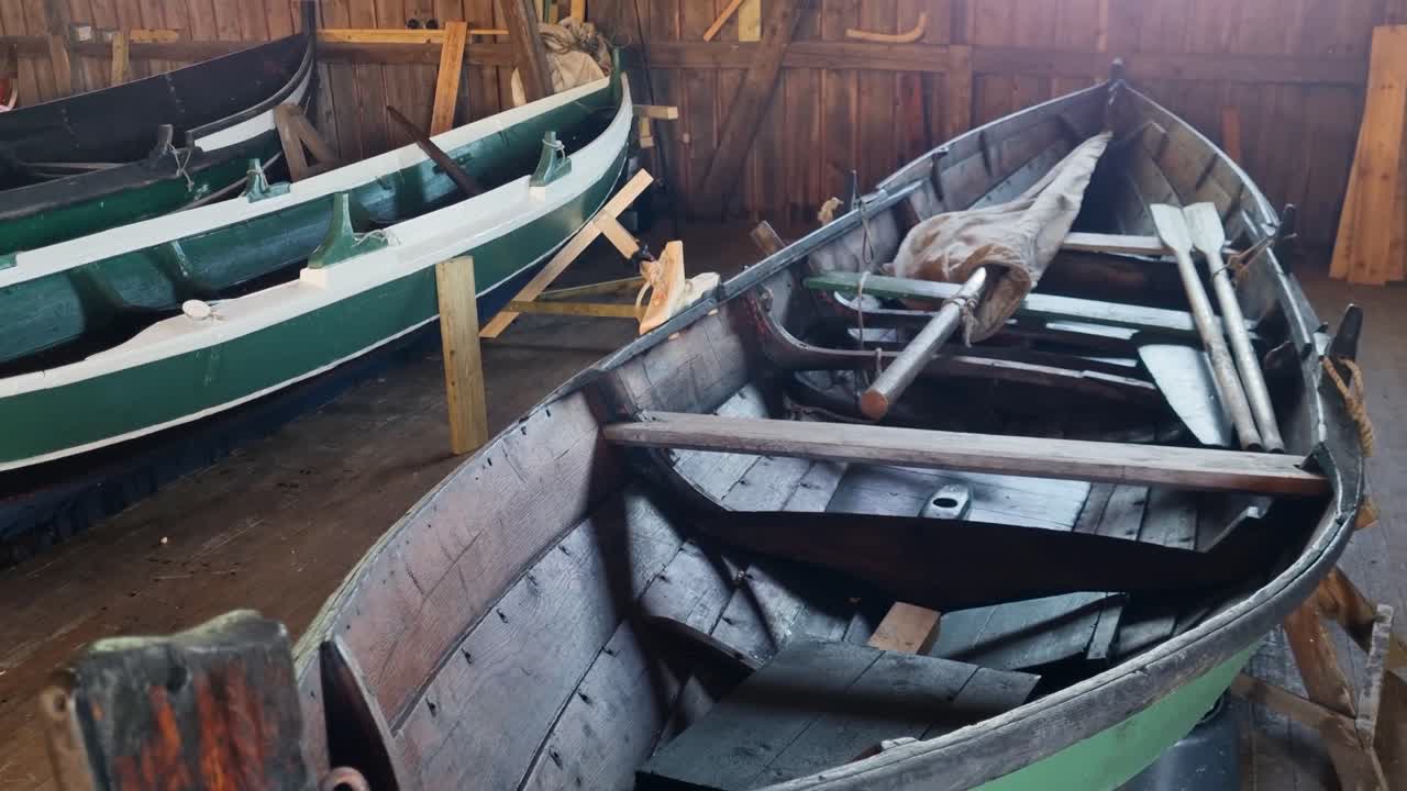 Close-up of a Viking-style wooden boat inside a rustic hall in Norway, detailed craftsmanship reflects Nordic heritage, seafaring tradition, and colorful maritime history