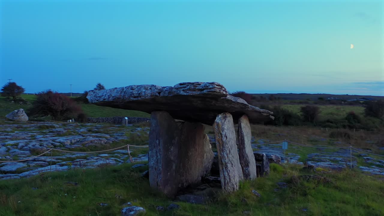 Luftfoto af Poulnabrone Dolmen i den blå time i Burren Nationalparks landskab, mens aftenlyset bliver dybere