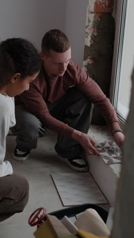 couple working together on home renovation project: tile installation