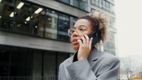 woman on phone in front of office building