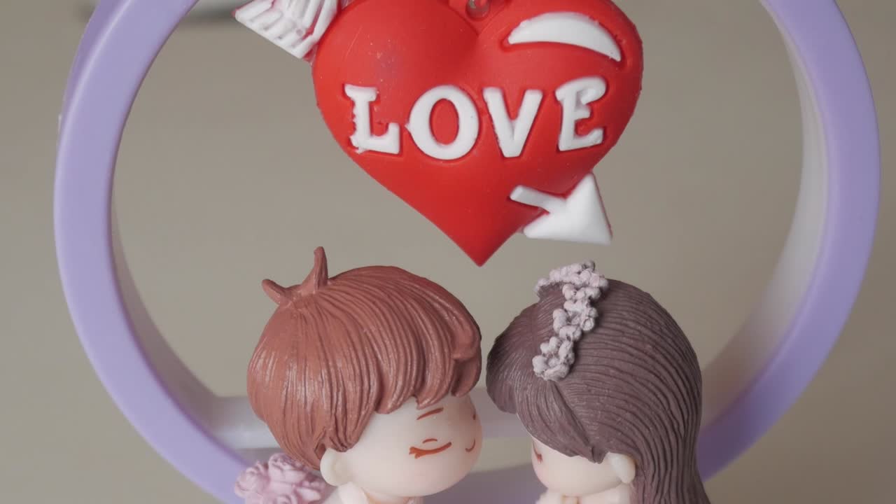 Lovers figurine with a red heart ornament and "LOVE" inscription for Valentine's Day