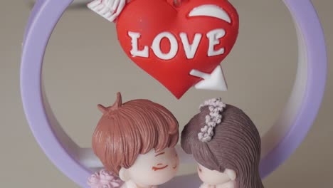 lovers figurine with a red heart ornament and "love" inscription for valentine's day