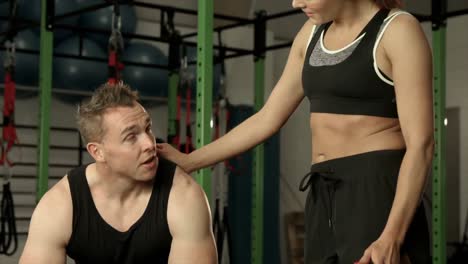 muscular man discussing with personal trainer