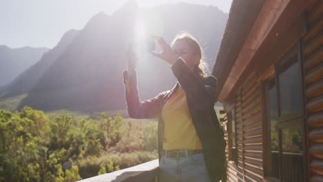 caucasian woman taking a picture of the landscape.