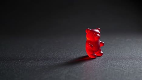 oso de goma rojo en fondo oscuro