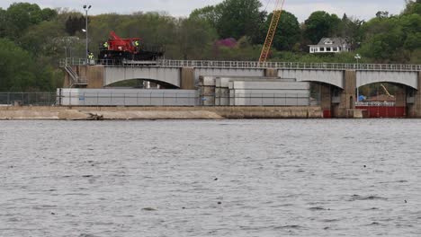 Operation-of-a-specialized-crane-to-repair-the-dam-rollers-of-Lock-and-Dam-number-14-on-the-Mississippi-River-near-LeClair-Iowa