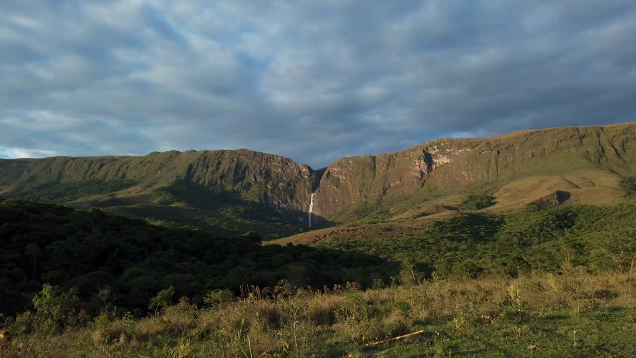 Timelapse of blue sky with moving clouds and distant waterfall in Serra da Canastra, Minas Gerais, Brazil