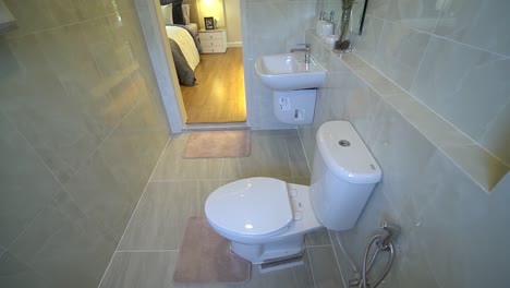 small restroom with light beige ceramic tile, no people, dolly