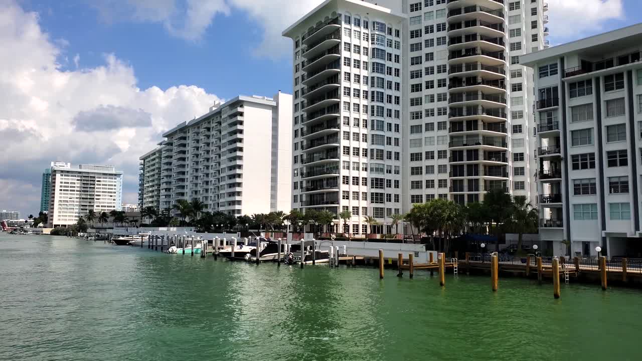 미아미의 수로를 가로질러 움직이는, 예쁜 집과 고층 건물