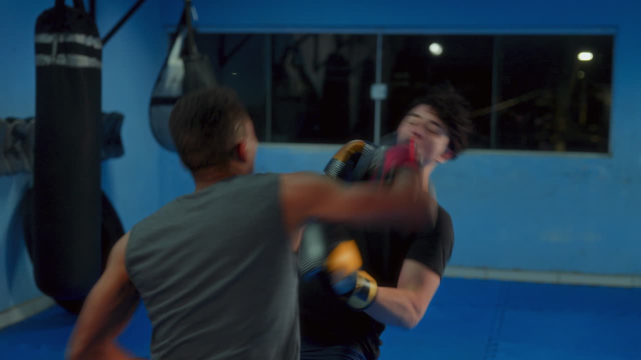 Two Men Sparring and Training in a Boxing Gym