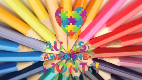 rompecabezas formando un corazón y texto del mes de concienciación sobre el autismo contra lápices de colores girando