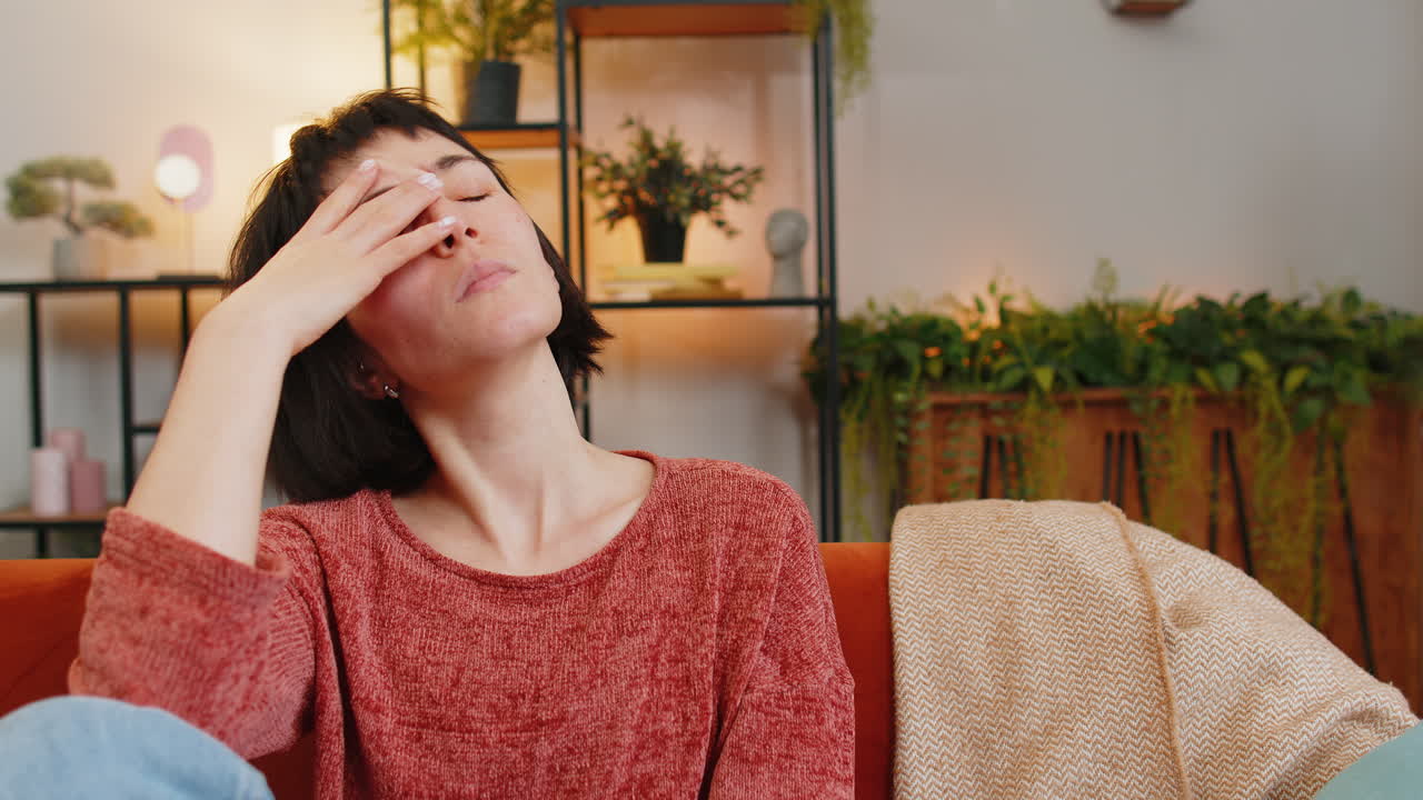 triste y angustiada joven caucásica parece pensativa deprimida sintiéndose mal molesta en el sofá del cuarto de casa